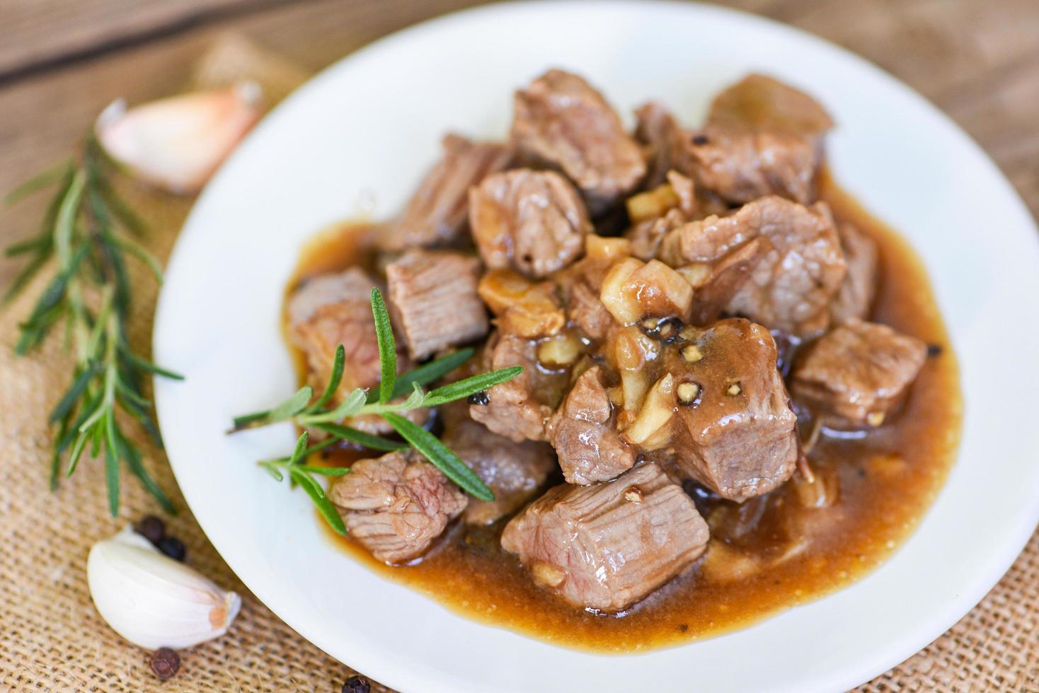 Cube de viande de bœuf rôti barbecue avec sauce et épices ail - coupes de bœuf et plats cuisinés sur plaque blanche photo