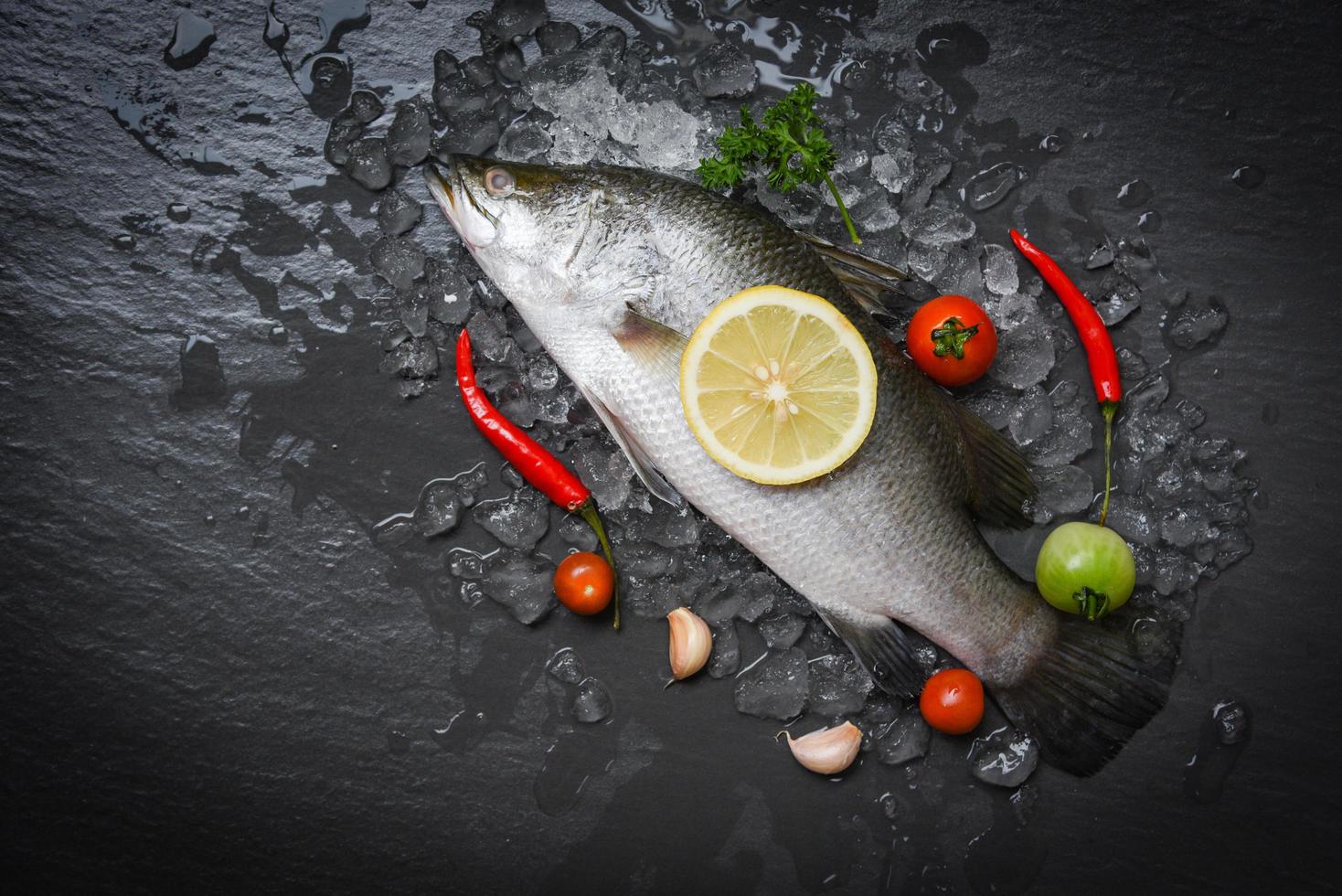 poisson de bar frais pour cuisiner avec des herbes et des épices photo