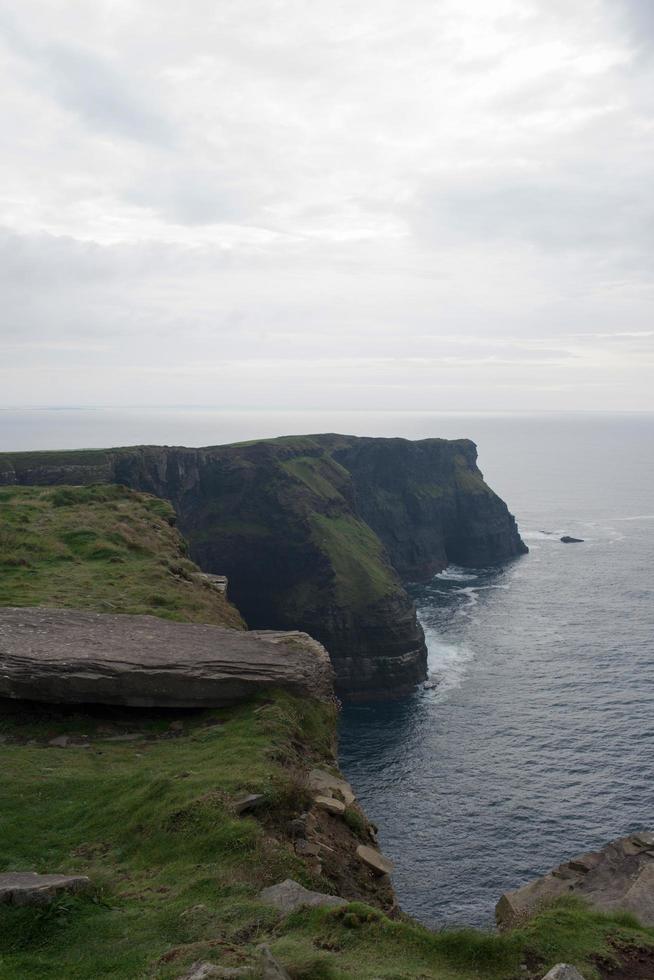 falaises de moher un jour de pluie. champs verts et eau calme. Irlande photo