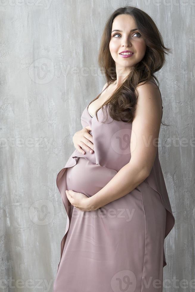 fille enceinte sur fond gris. photo