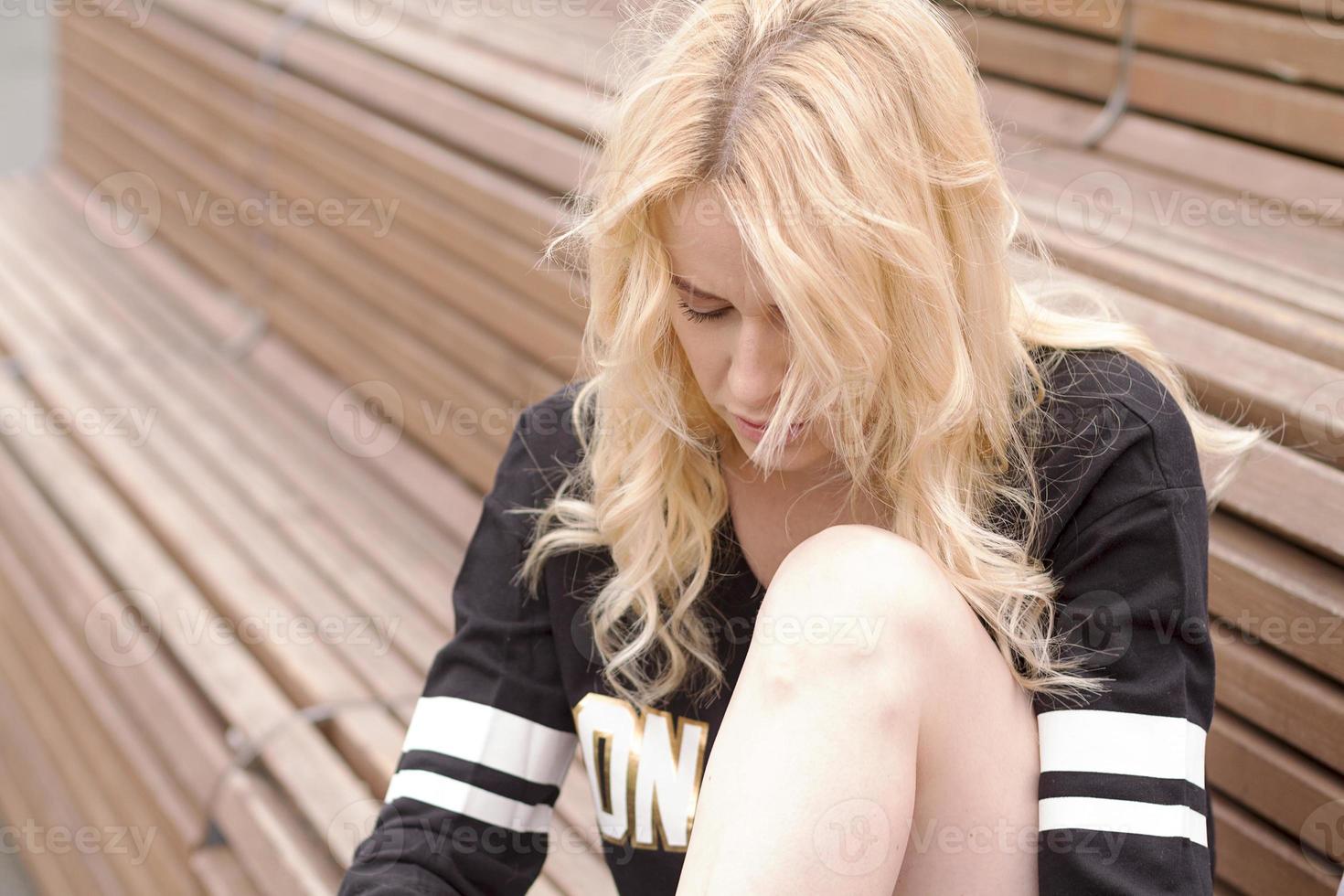 la fille est assise sur le banc du terrain de football avec le ballon. photo