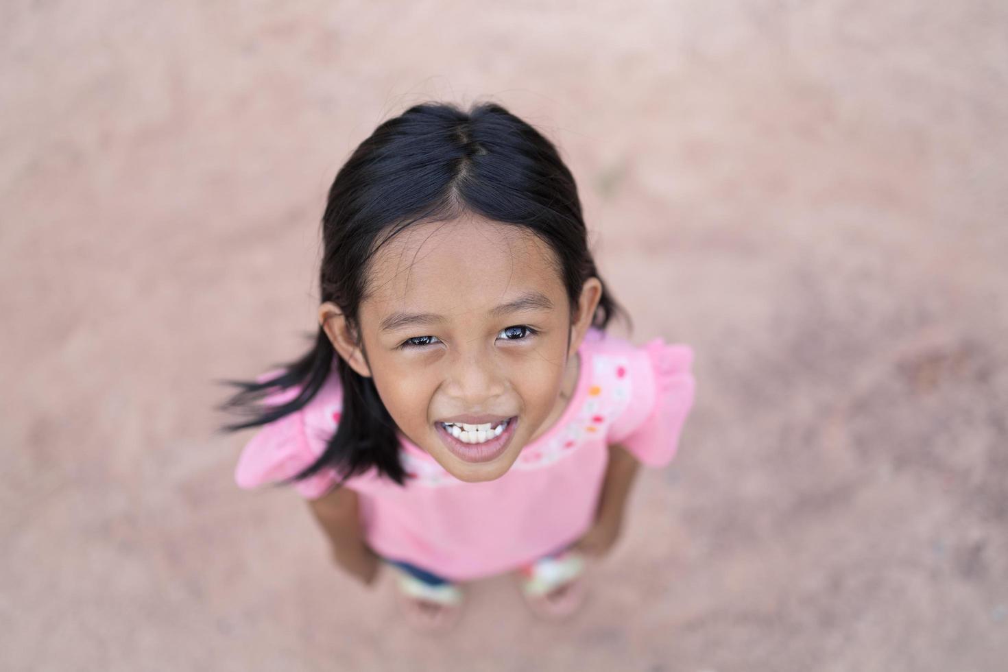 un portrait d'une petite fille asiatique debout sur le sol. photo