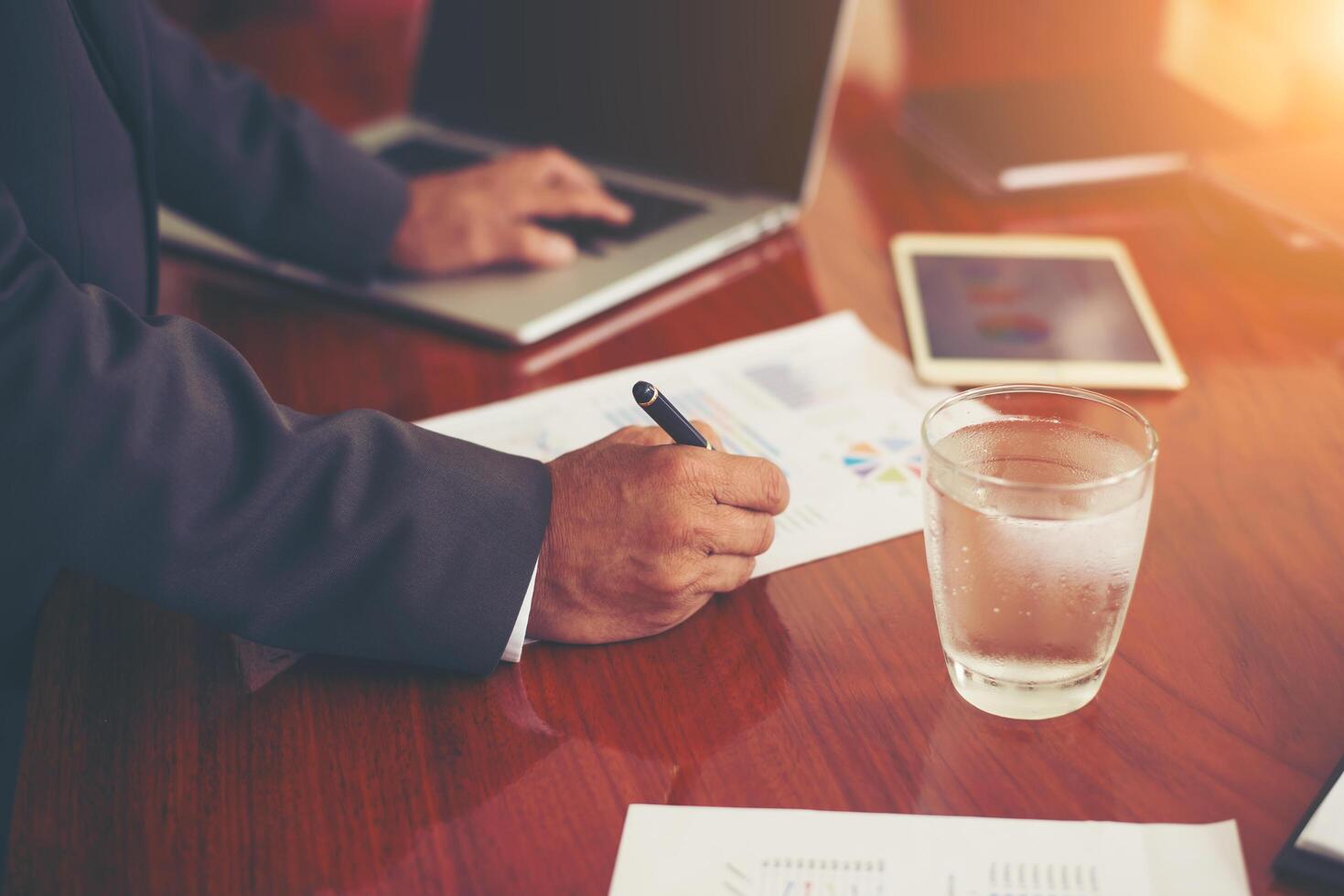 la main de l'homme d'affaires avec un stylo écrit sur le papier d'affaires. tableau de rapport, occupé au travail. photo