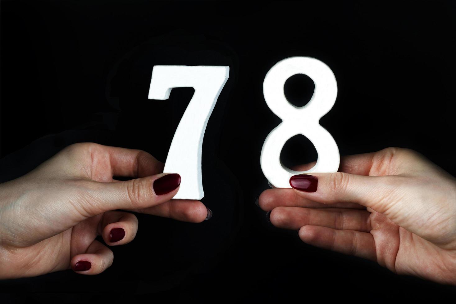 aux mains féminines le chiffre de soixante-dix-huit. photo