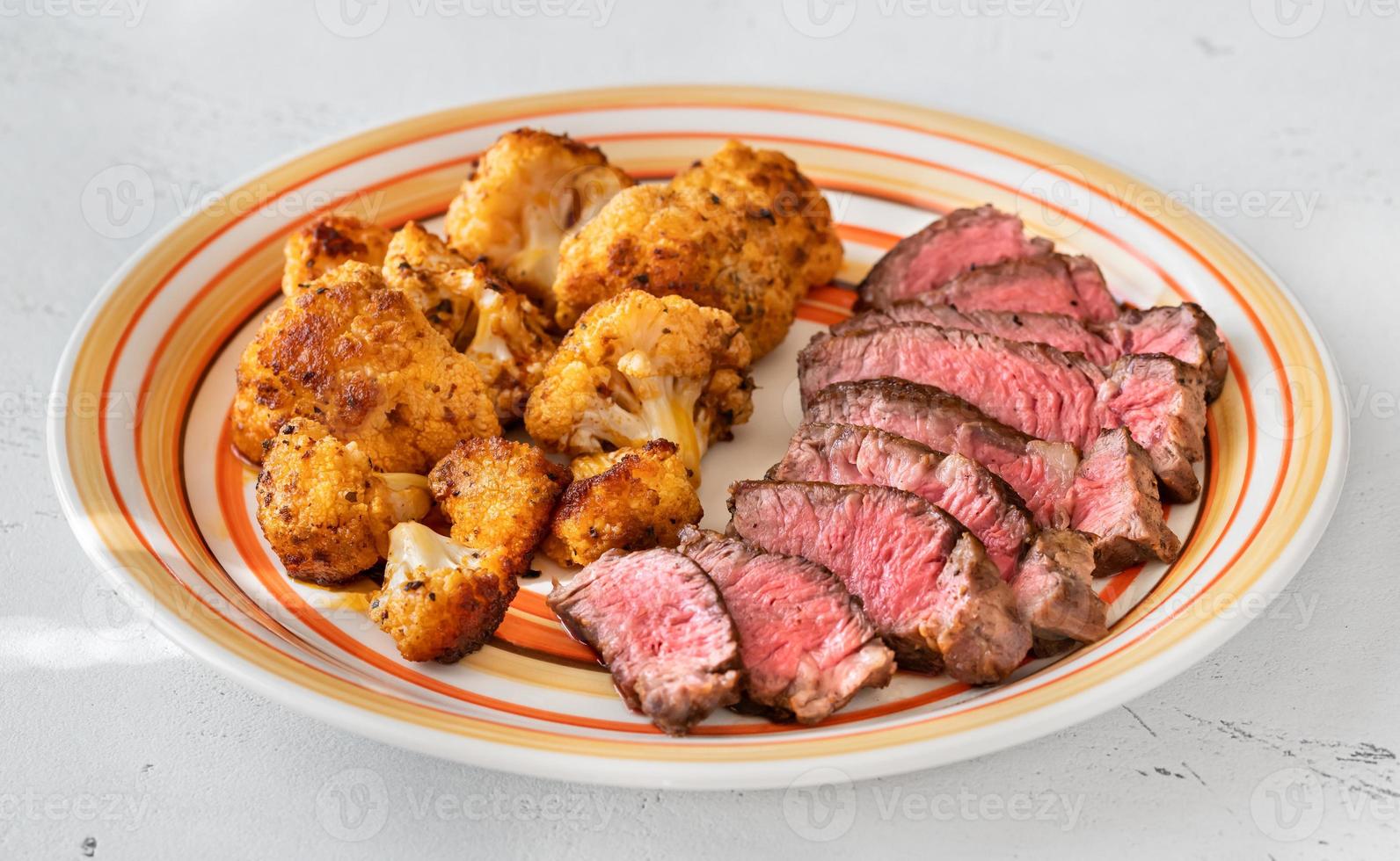 steak de boeuf tranché avec chou-fleur au four photo
