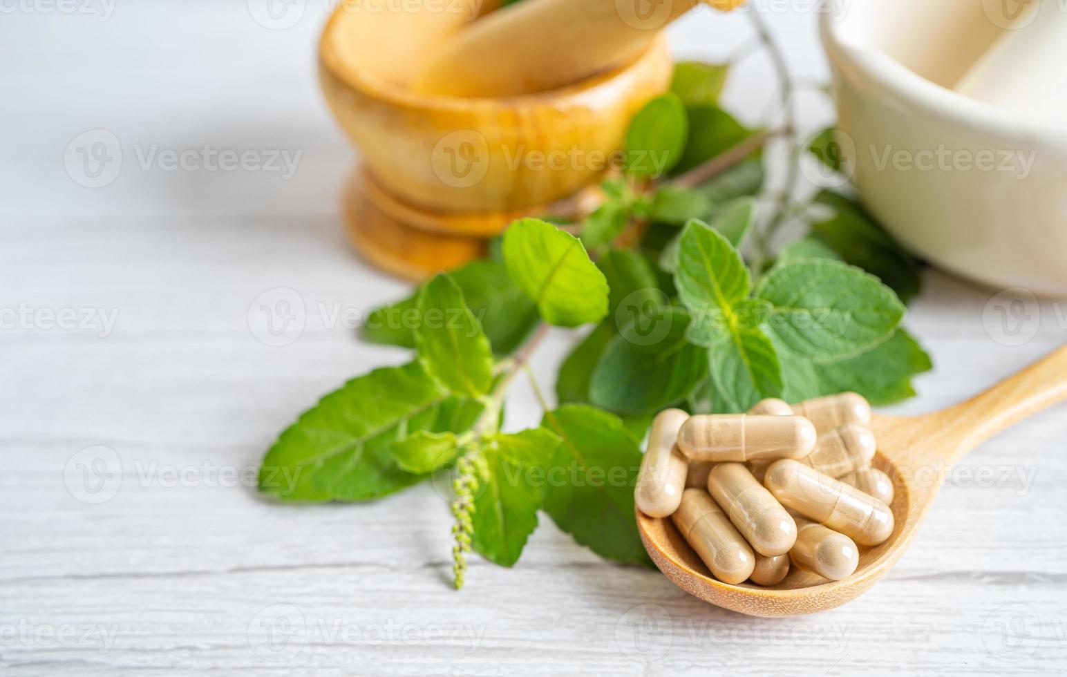 médecine alternative capsule bio à base de plantes avec des suppléments naturels de feuilles d'herbes pour une bonne vie saine. photo