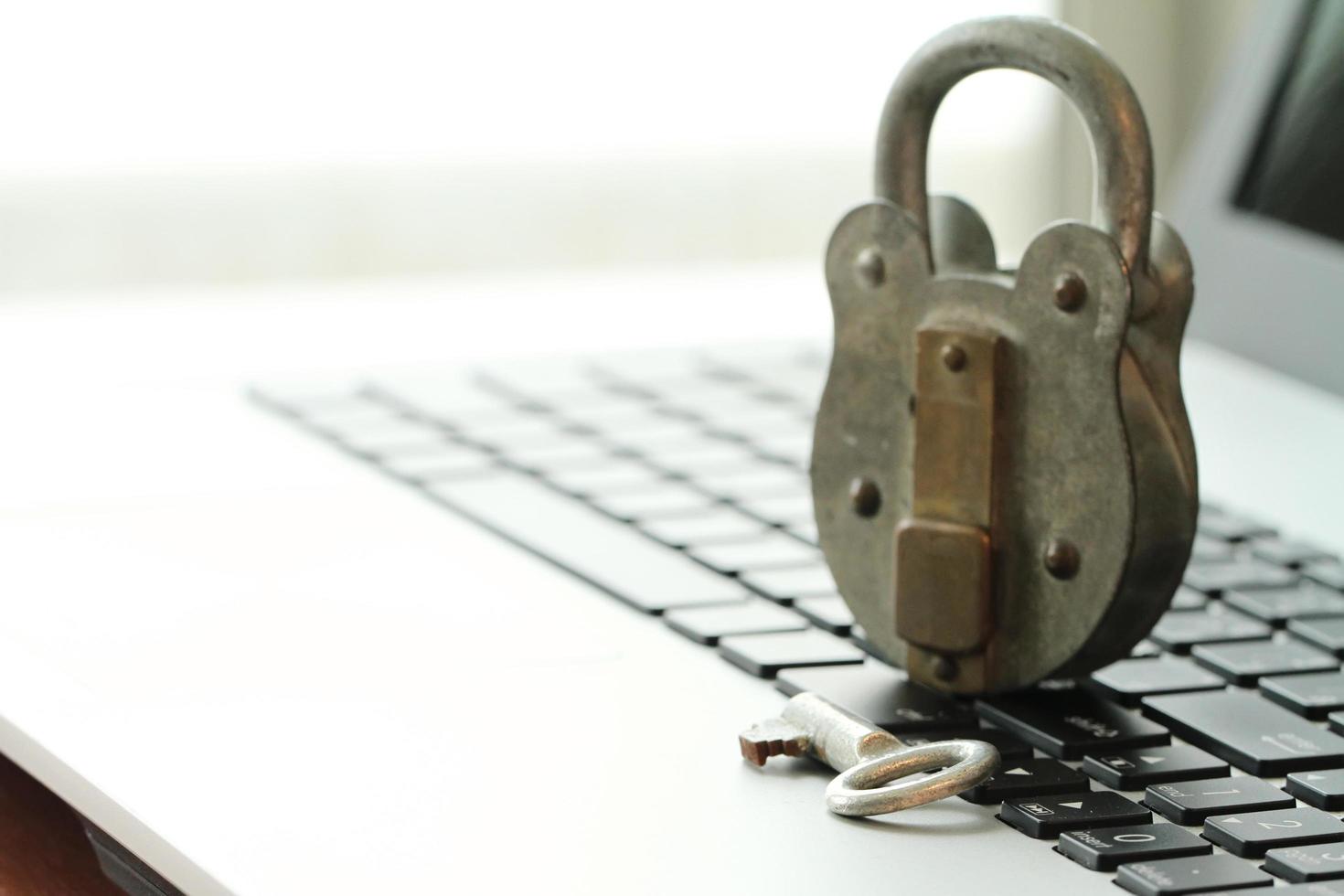 concept de sécurité internet-homme d'affaires miniature debout sur l'ancienne clé et cadenas sur le clavier de l'ordinateur portable photo