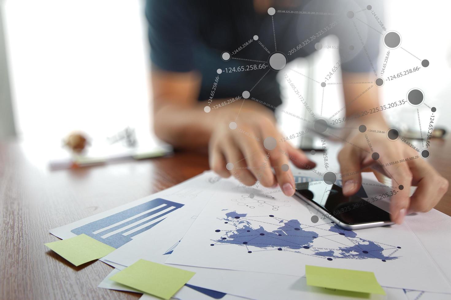 documents d'affaires sur la table de bureau avec téléphone intelligent et tablette numérique et homme travaillant en arrière-plan photo