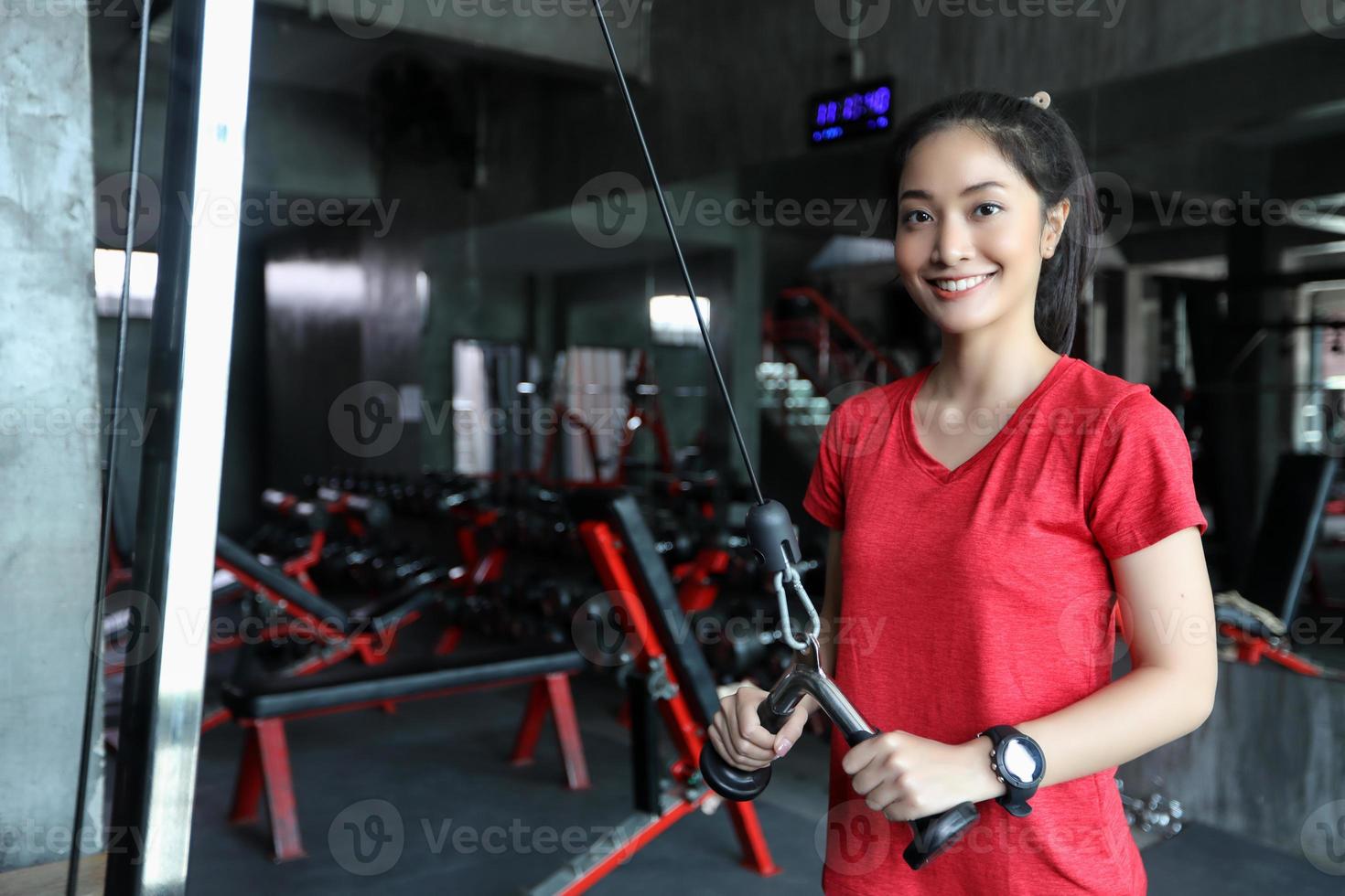 belle femme en forme musculaire exerçant des muscles de construction et femme de remise en forme faisant des exercices dans la salle de gym. remise en forme - concept de mode de vie sain photo