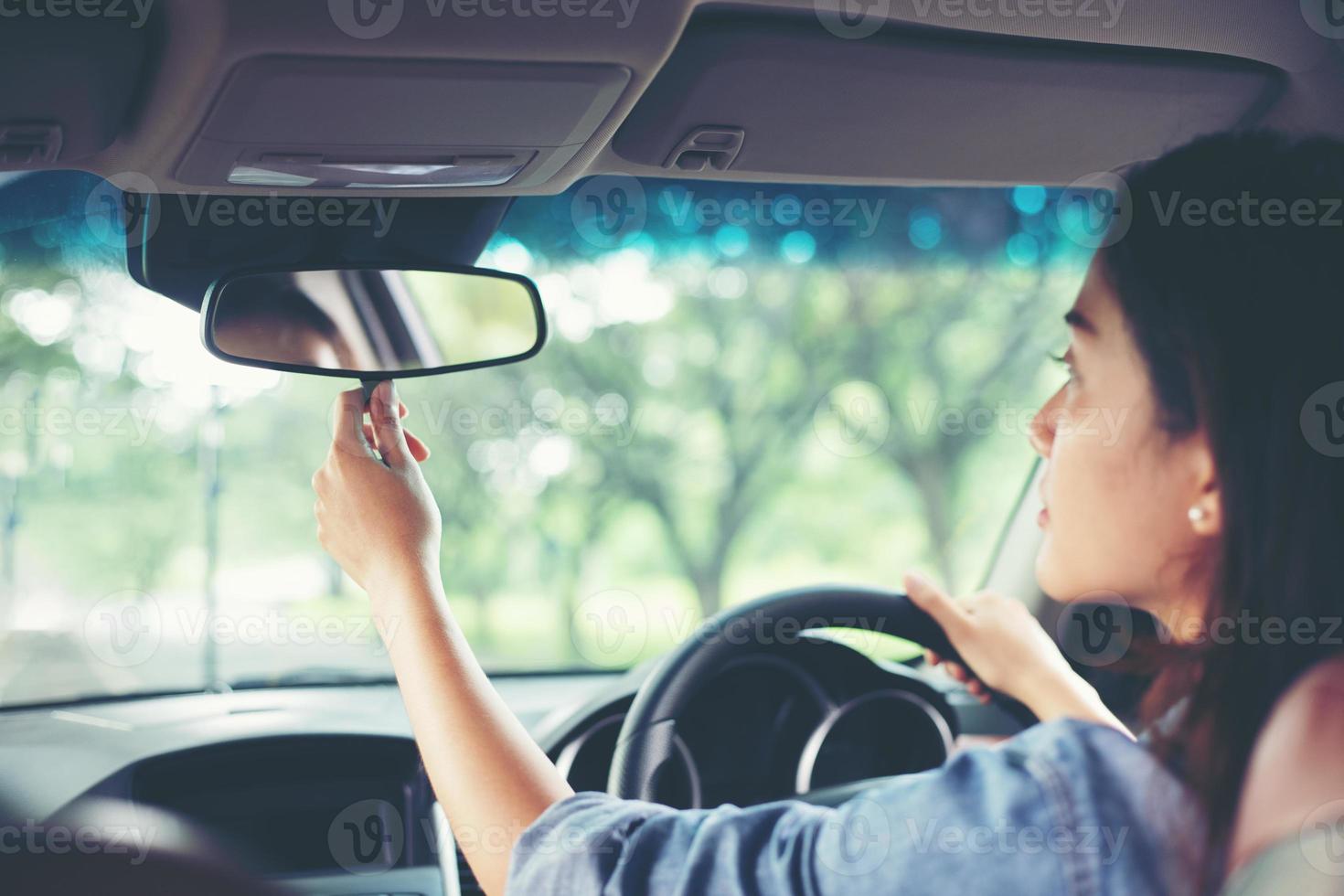 les femmes asiatiques ajustent le rétroviseur de la voiture photo