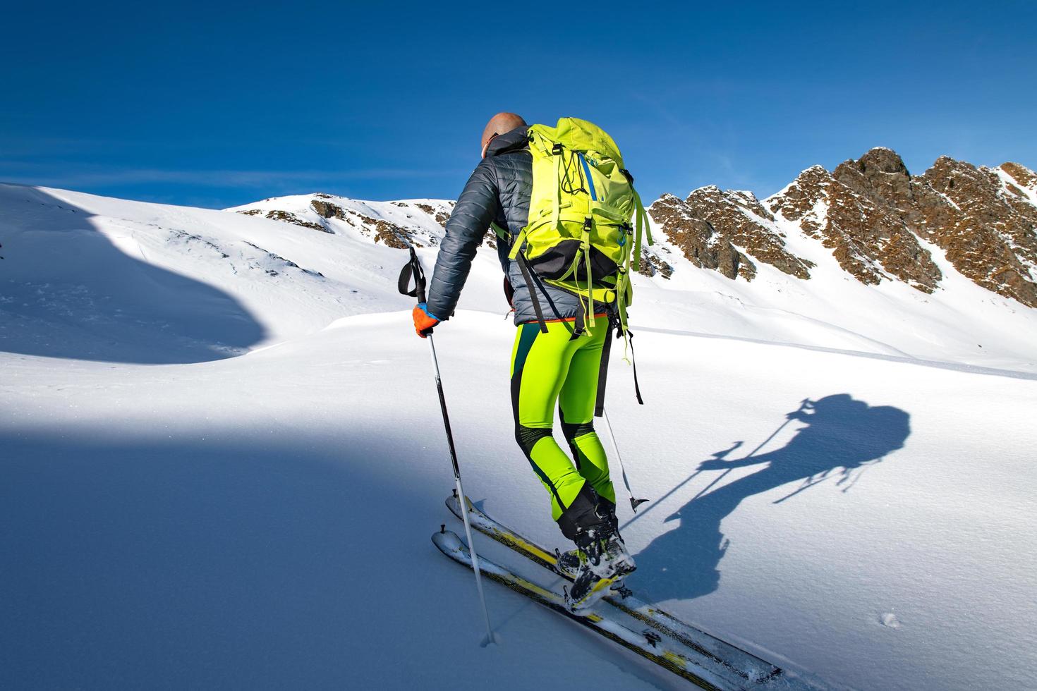 grimper avec des skis et des peaux de phoque dans la neige vierge photo