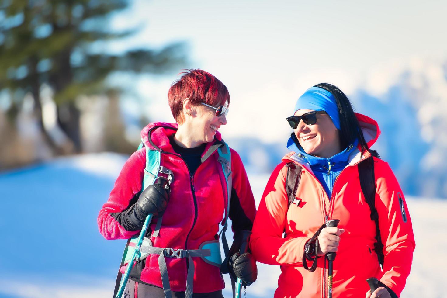 Happy young woman couple lors d'une randonnée dans la neige photo