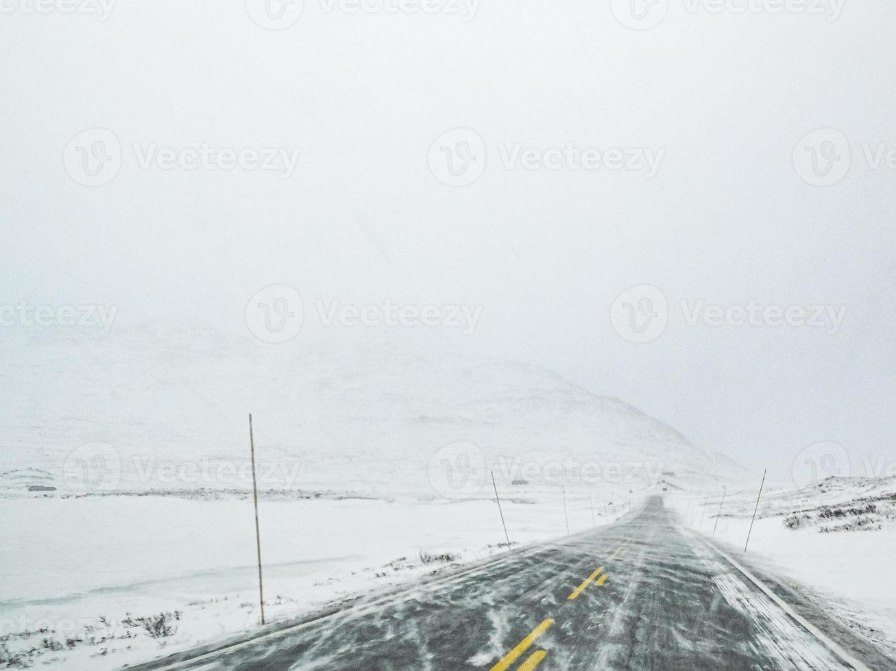 conduite à travers une tempête de neige blizzard avec de la glace noire sur la route, en norvège. photo