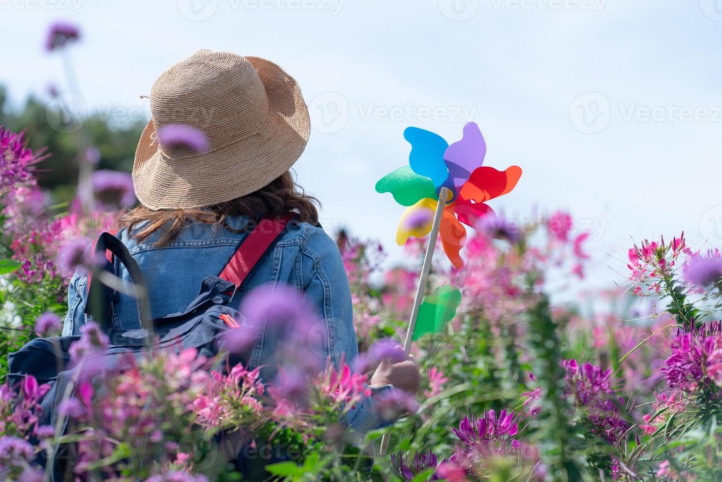 portrait de femme marchant dans un champ de fleurs roses en été photo