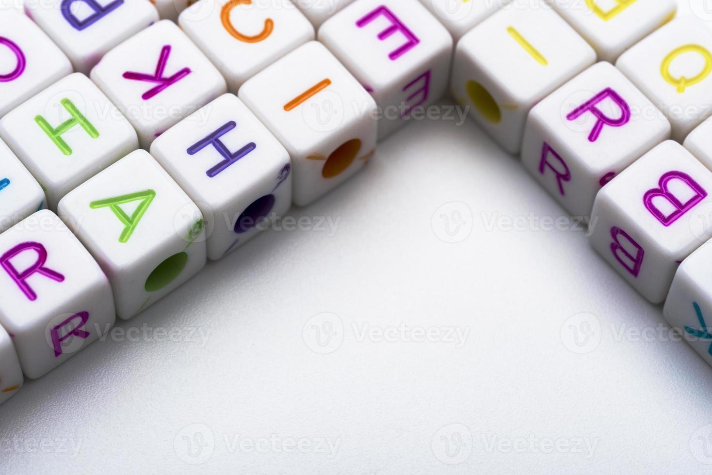 de nombreux cubes décoratifs colorés avec des lettres sur fond blanc. photo