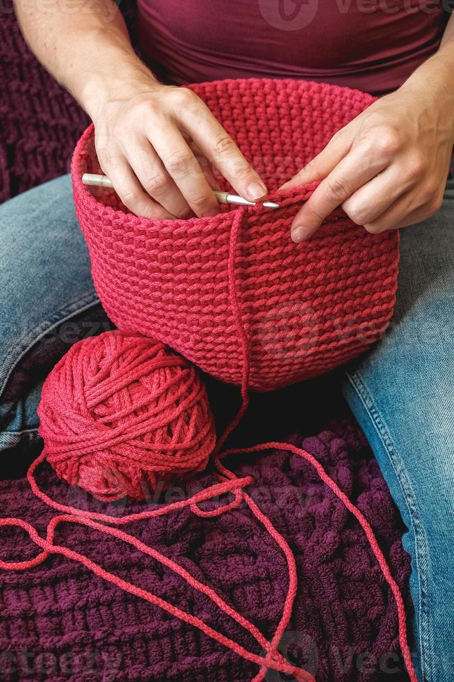 mains femme dans une maison confortable tricote à partir d'un fil rose. copie, espace vide pour le texte photo