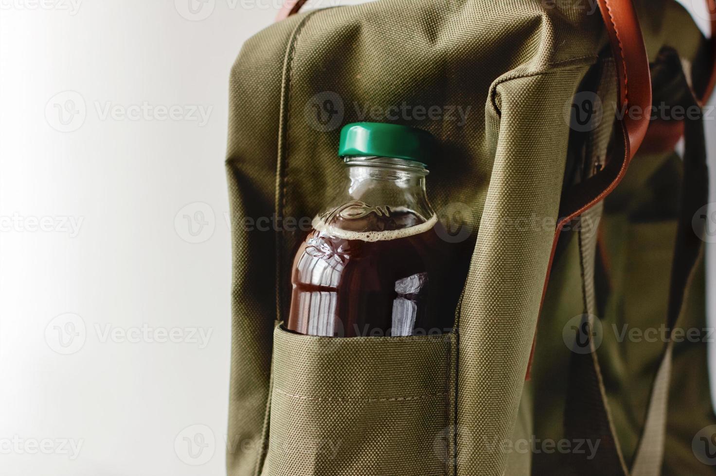 café froid à emporter. boisson froide dans une bouteille dans la poche du sac à dos. photo