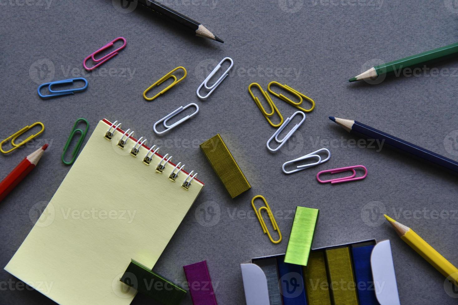 bloc-notes crayons et trombones sur le bureau photo