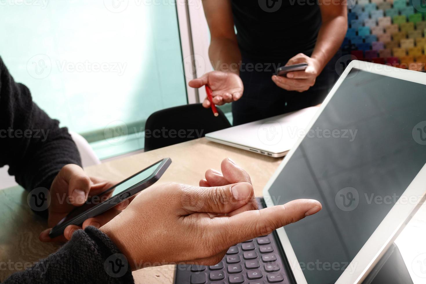 deux collègues concepteurs de sites Web discutant de données et d'un clavier d'accueil pour tablette numérique et d'un ordinateur portable avec un smartphone et un schéma de conception sur un bureau en marbre, effet de lumière du soleil photo