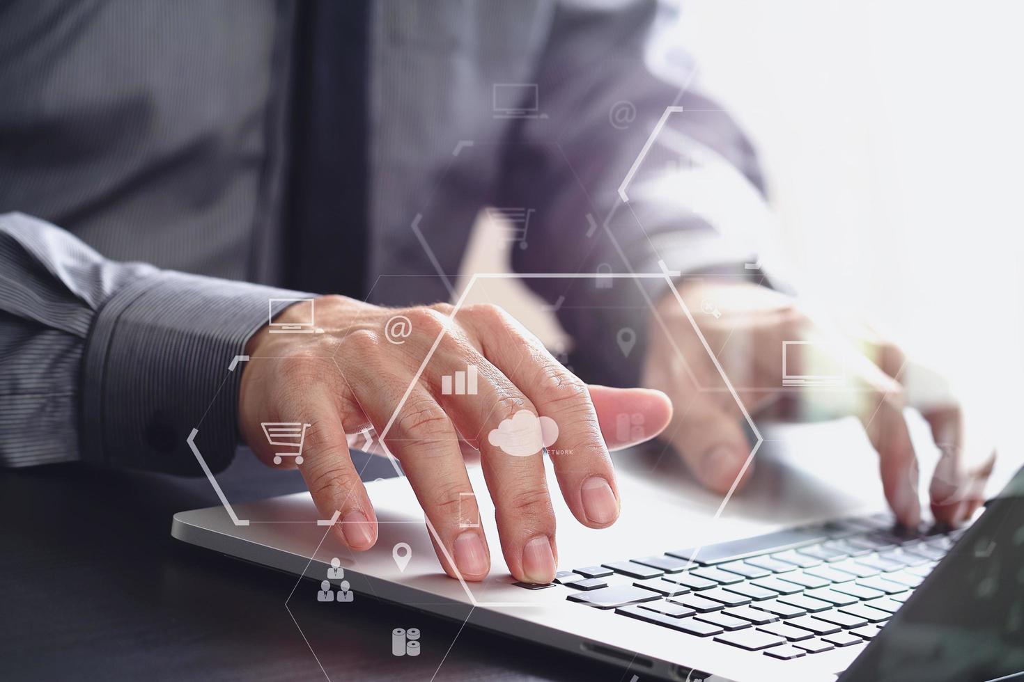 gros plan sur un homme d'affaires travaillant avec un ordinateur portable sur un bureau en bois dans un bureau moderne avec un diagramme d'icône virtuelle photo