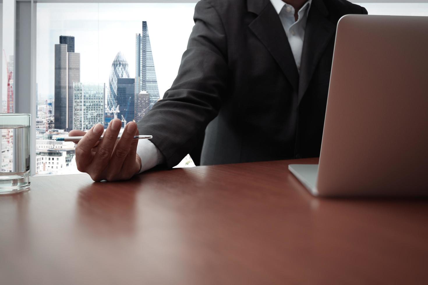 documents d'affaires sur la table de bureau avec téléphone intelligent et tablette numérique et graphique diagramme d'affaires et homme travaillant en arrière-plan photo