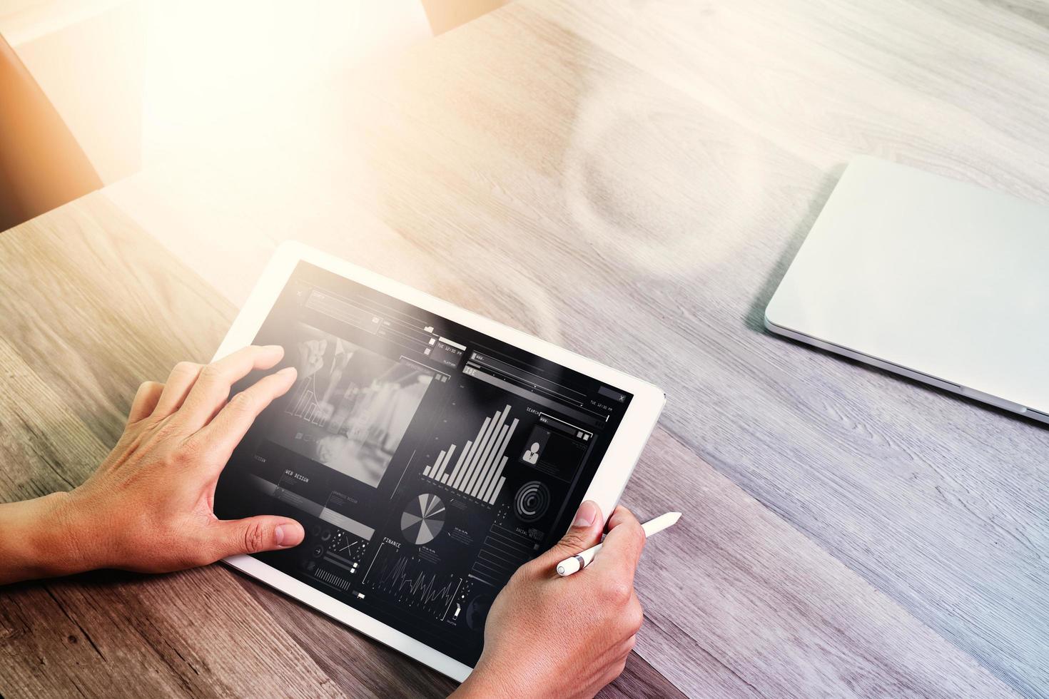 main d'homme d'affaires travaillant avec stylet tablette numérique téléphone intelligent et ordinateur portable. assister à une vidéoconférence dans un bureau moderne. sur un bureau en bois. vue de dessus. effets de double exposition, minimalisme photo