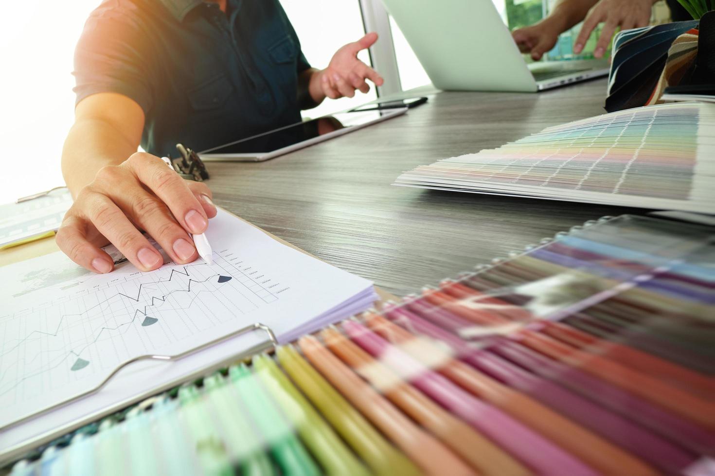 deux collègues architecte d'intérieur discutant de données et d'une tablette numérique et d'un ordinateur portable avec un échantillon de matériel et un diagramme de conception numérique sur un bureau en bois en tant que concept photo