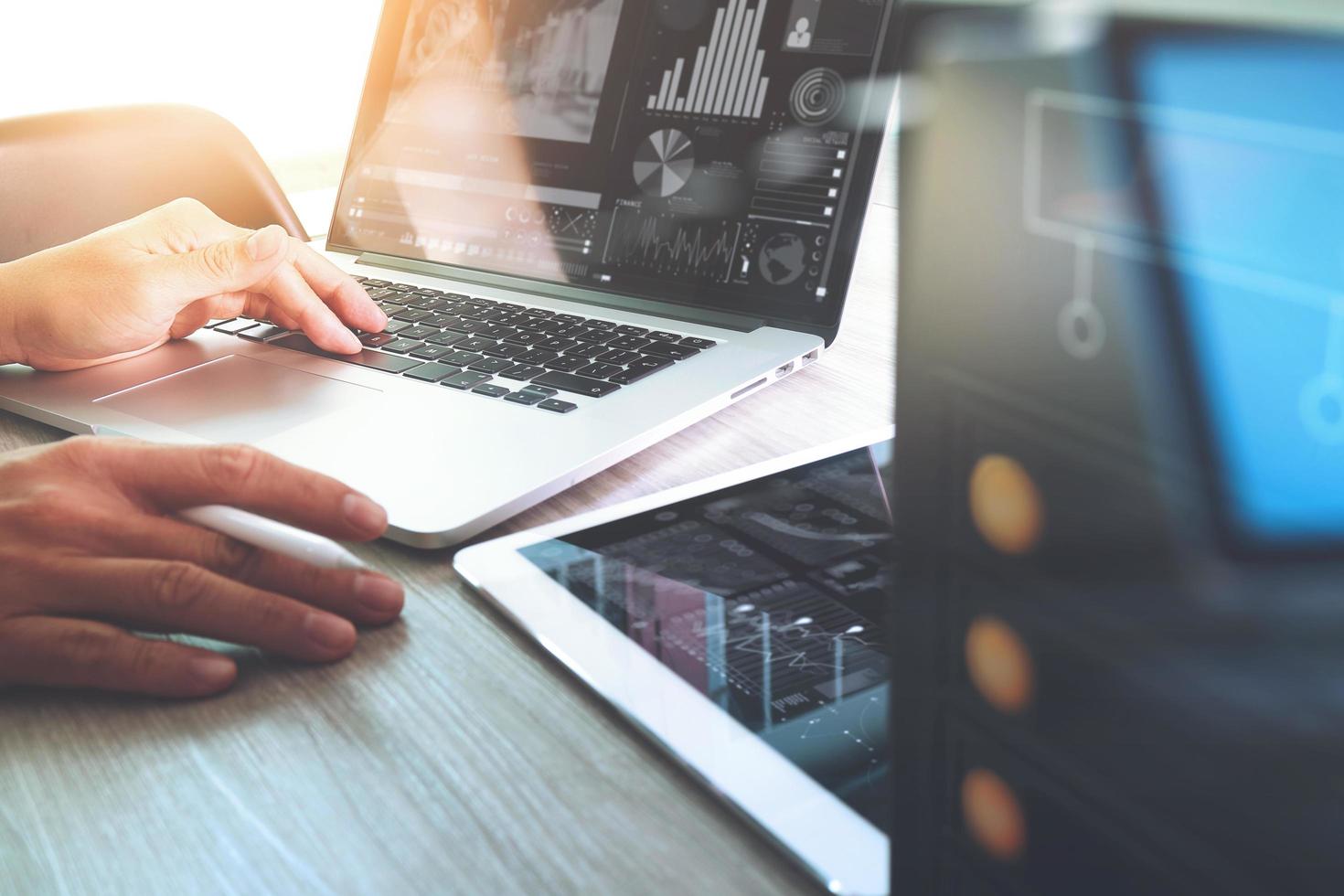 concepteur de site Web travaillant sur une tablette numérique et un ordinateur portable avec une tablette numérique et un diagramme de conception numérique sur un bureau en bois et un serveur compact photo