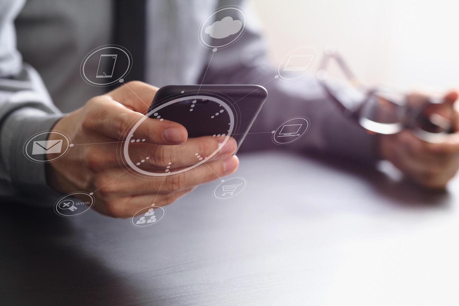 gros plan sur un homme d'affaires travaillant avec un téléphone portable et des lunettes sur un bureau en bois dans un bureau moderne photo