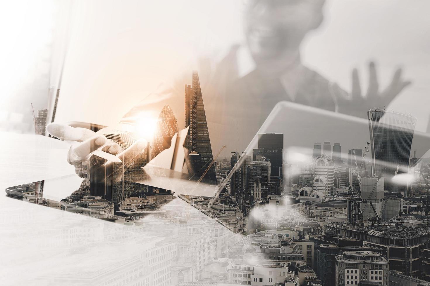 double exposition d'un homme d'affaires prospère travaillant au bureau avec un ordinateur portable à tablette numérique avec un bâtiment de Londres et un téléphone intelligent, effet de filtre photo