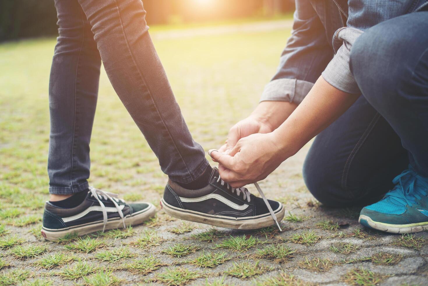 petit ami hipster attachant des chaussures à ses filles tout en se relaxant en vacances, concept de couple amoureux. photo