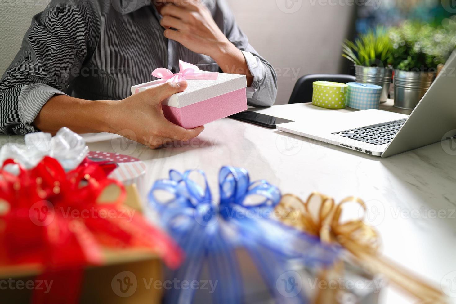 cadeau donnant la main créative choisissant et main avec cadeau. livraison de cadeaux, surprise, ordinateur portable et téléphone intelligent sur un bureau mable, effet de film filtrant photo