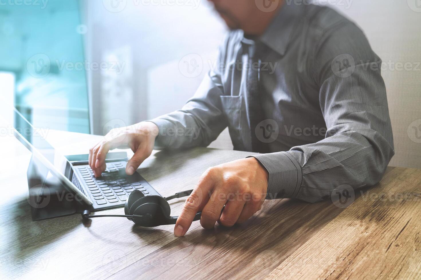 homme utilisant un casque voip avec un clavier intelligent d'accueil pour ordinateur tablette numérique, communication conceptuelle, support informatique, centre d'appels et service client, effet de film de filtre photo