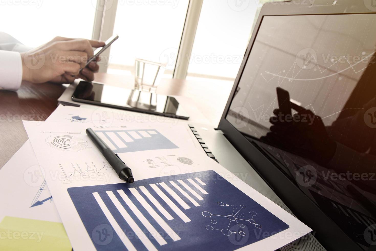 documents d'affaires sur la table de bureau avec téléphone intelligent et tablette numérique et graphique diagramme d'affaires et homme travaillant en arrière-plan photo