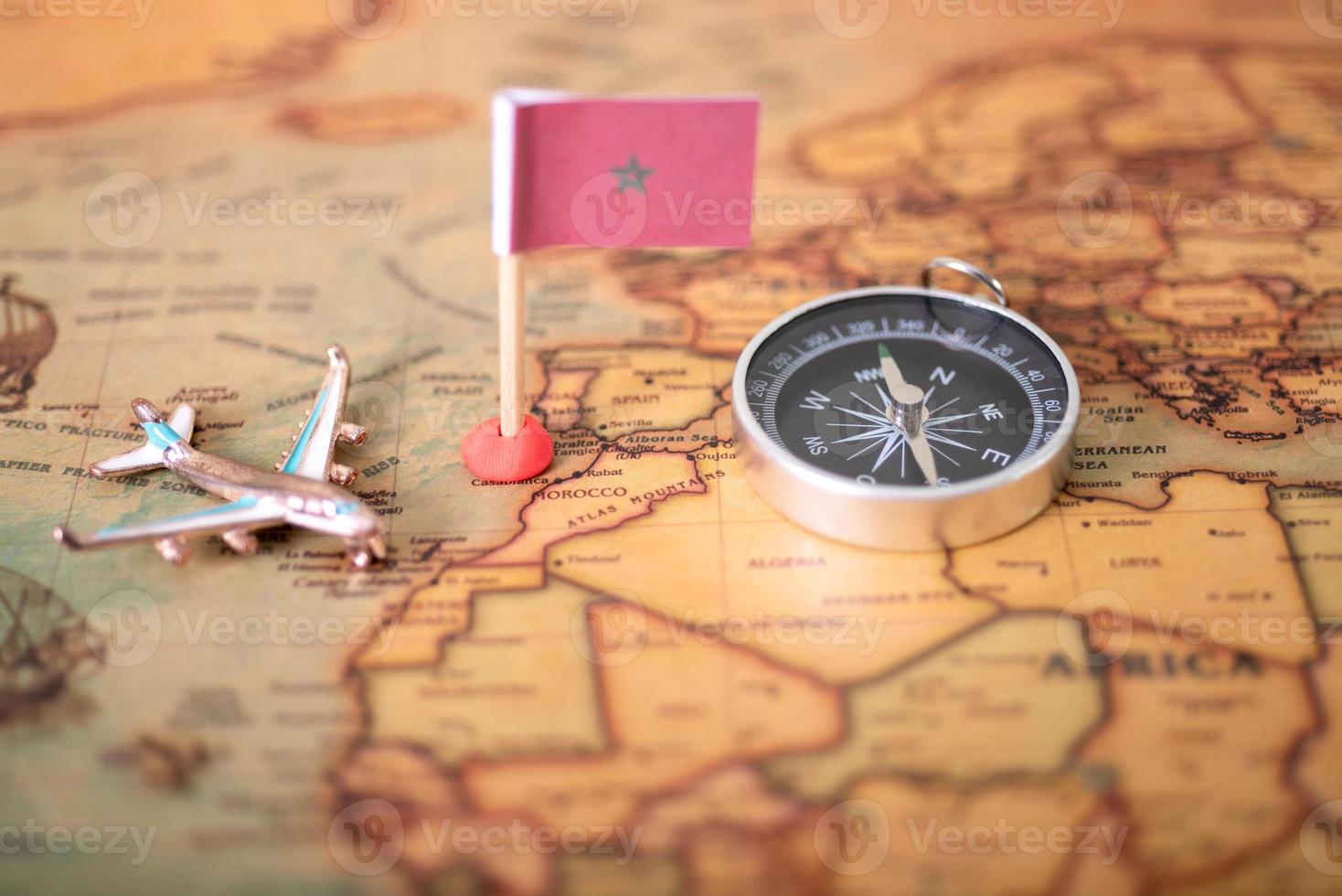 drapeau du maroc boussole et avion sur la carte du monde. photo