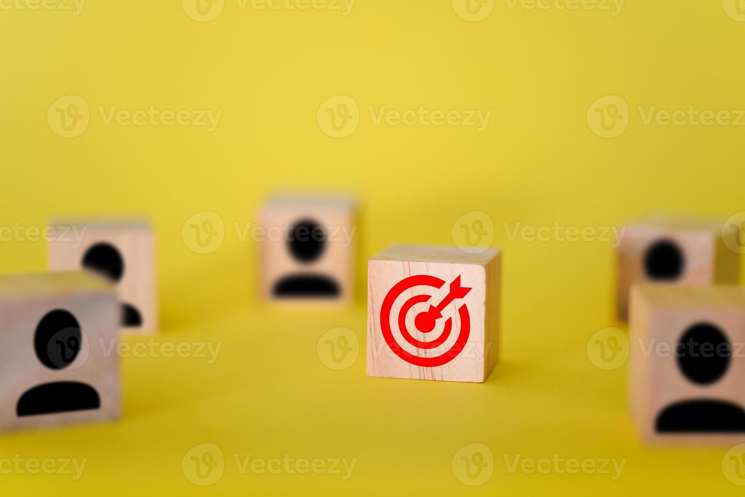 la cible est sur des cubes en bois, autour de la cible se trouvent des signes de personnes sur des cubes en bois, fond jaune. photo