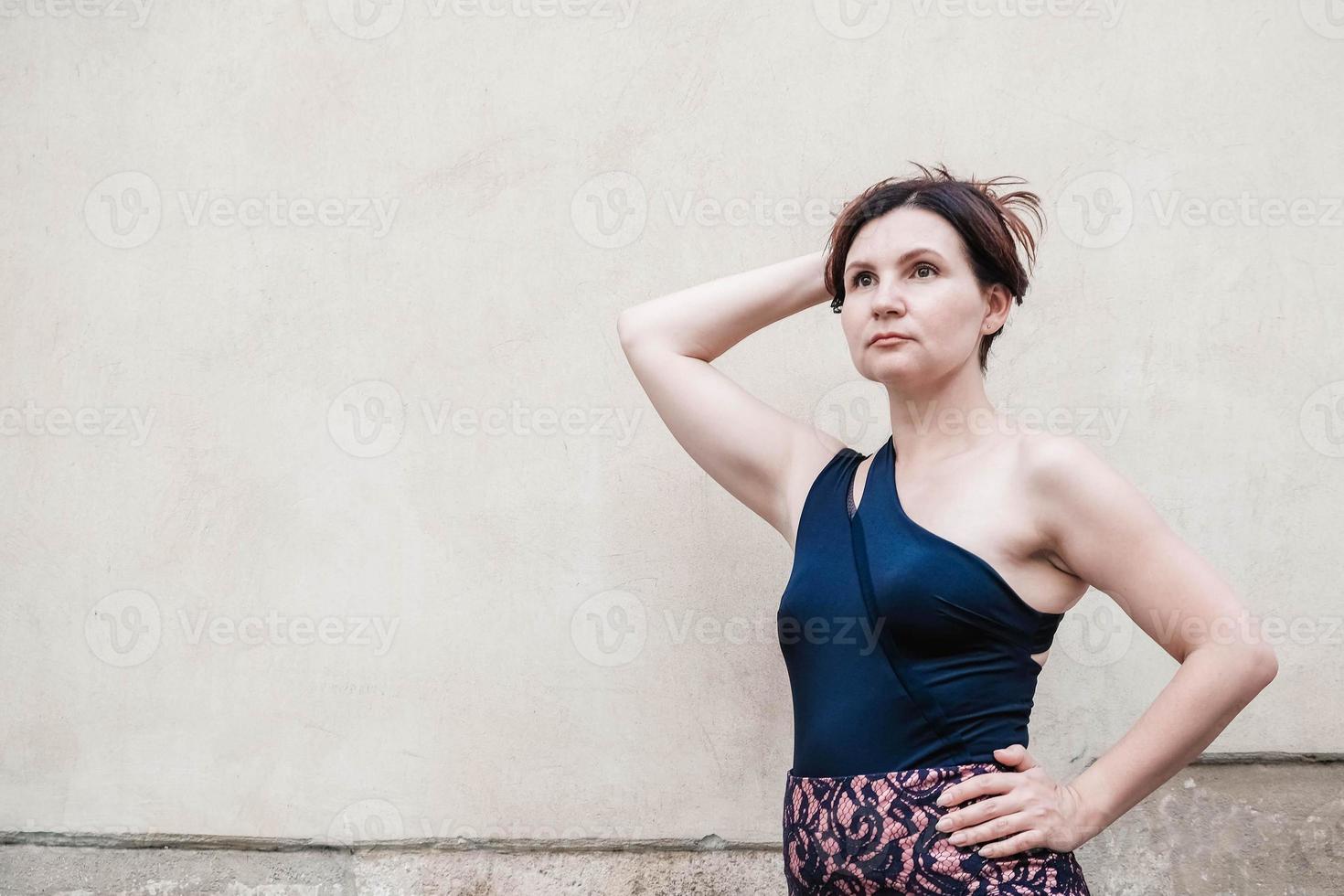 portrait d'une belle femme vêtue d'une robe sur le fond du vieux mur. copie, espace vide pour le texte photo