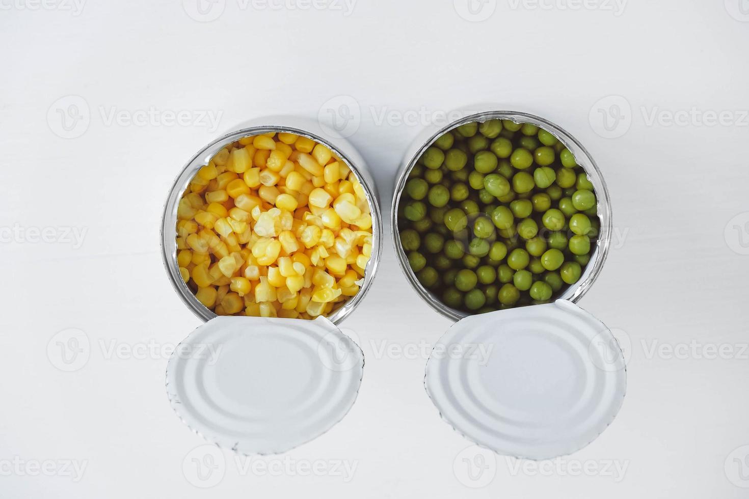 deux boîtes ouvertes avec du maïs et des pois sur fond blanc. vue de dessus. copie, espace vide pour le texte photo