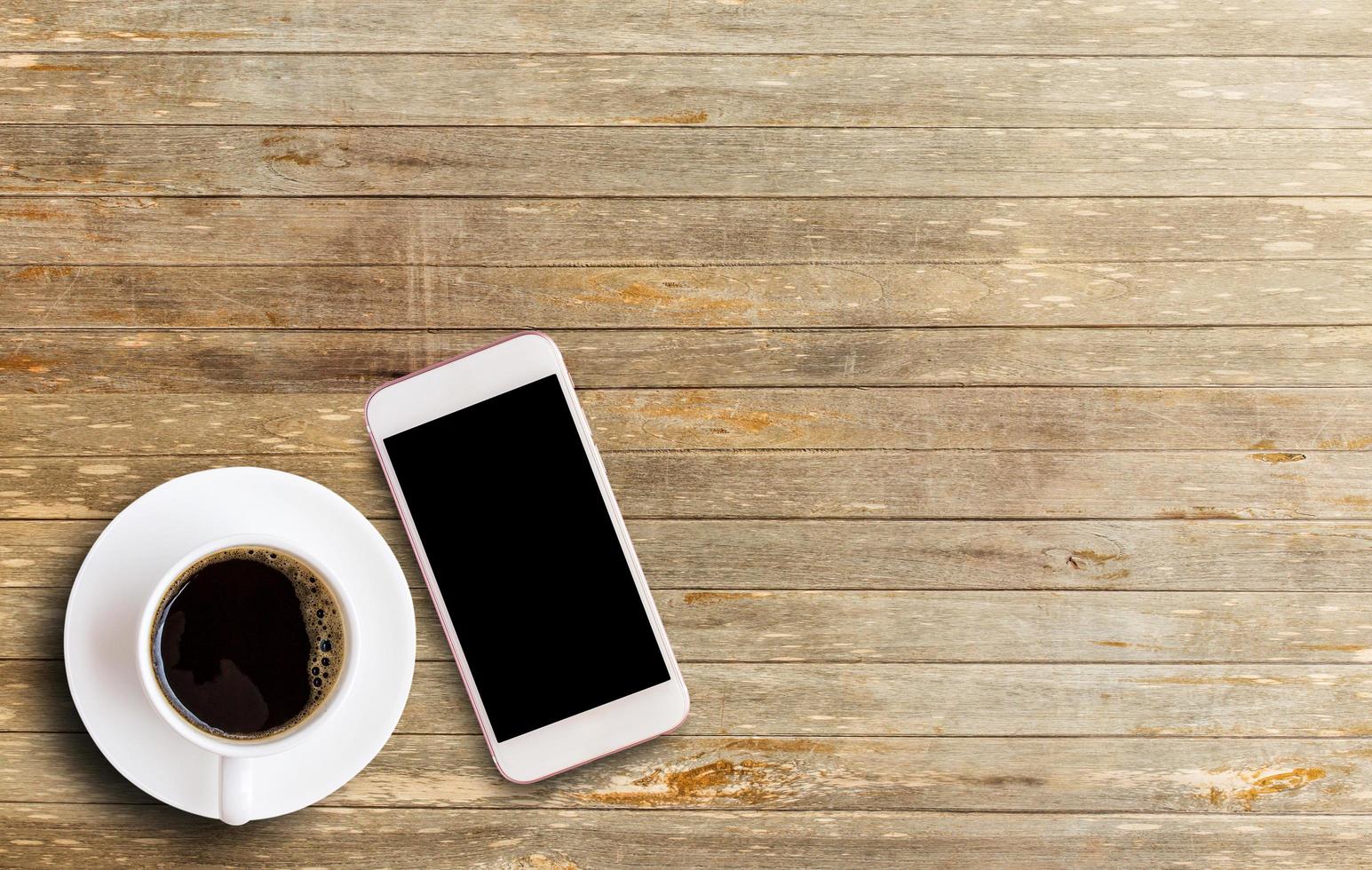 téléphone intelligent avec zone d'écran vierge et tasse à café photo