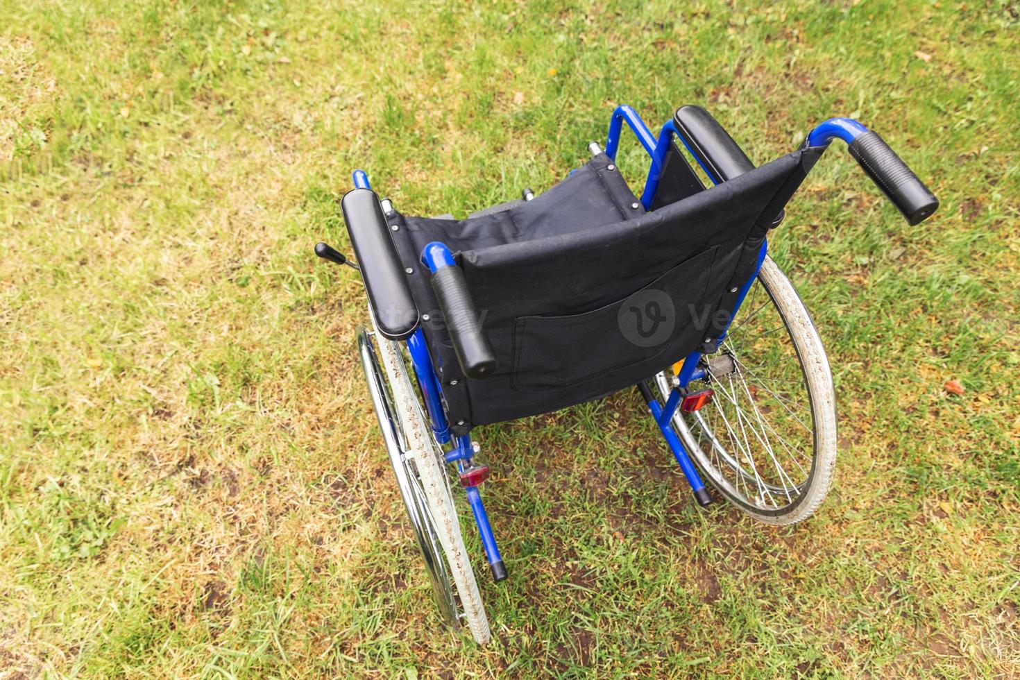fauteuil roulant vide debout dans le parc de l'hôpital en attente de services aux patients. fauteuil roulant pour personne handicapée garé à l'extérieur. accessible pour personne handicapée. concept médical de soins de santé. photo