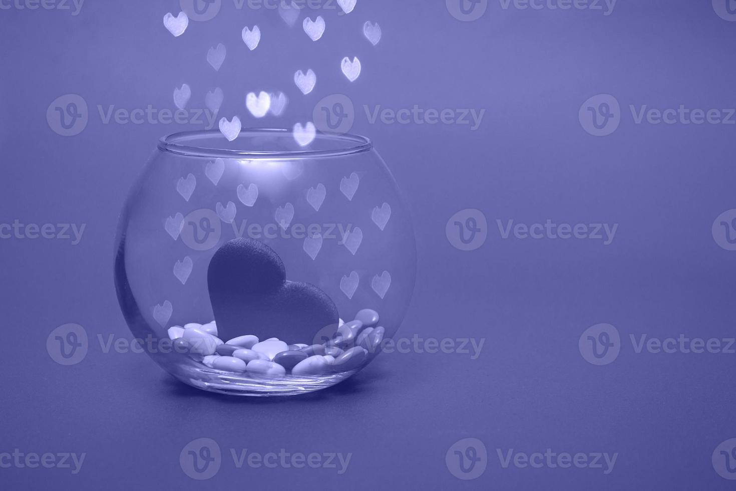 coeurs dans un vase rond transparent sur un fond très peri bokeh avec des coeurs. fond de vacances saint valentin ou fête des mères. copier le texte de l'espace. photo