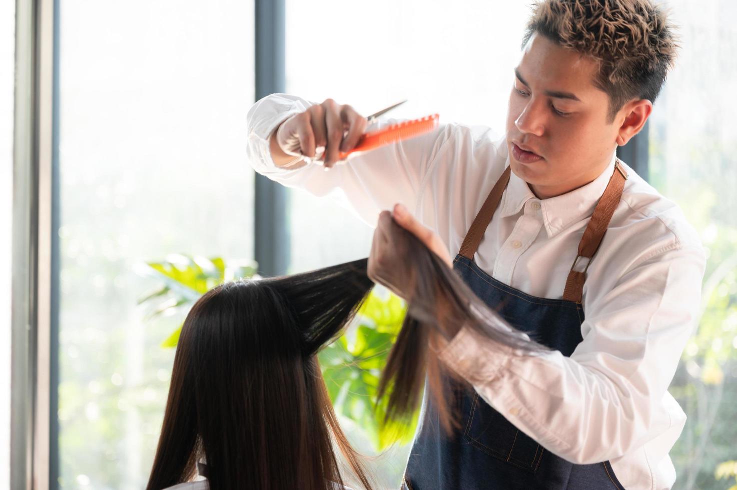 femme cliente ayant un processus de traitement d'un cheveu avec un coiffeur dans un salon de beauté photo