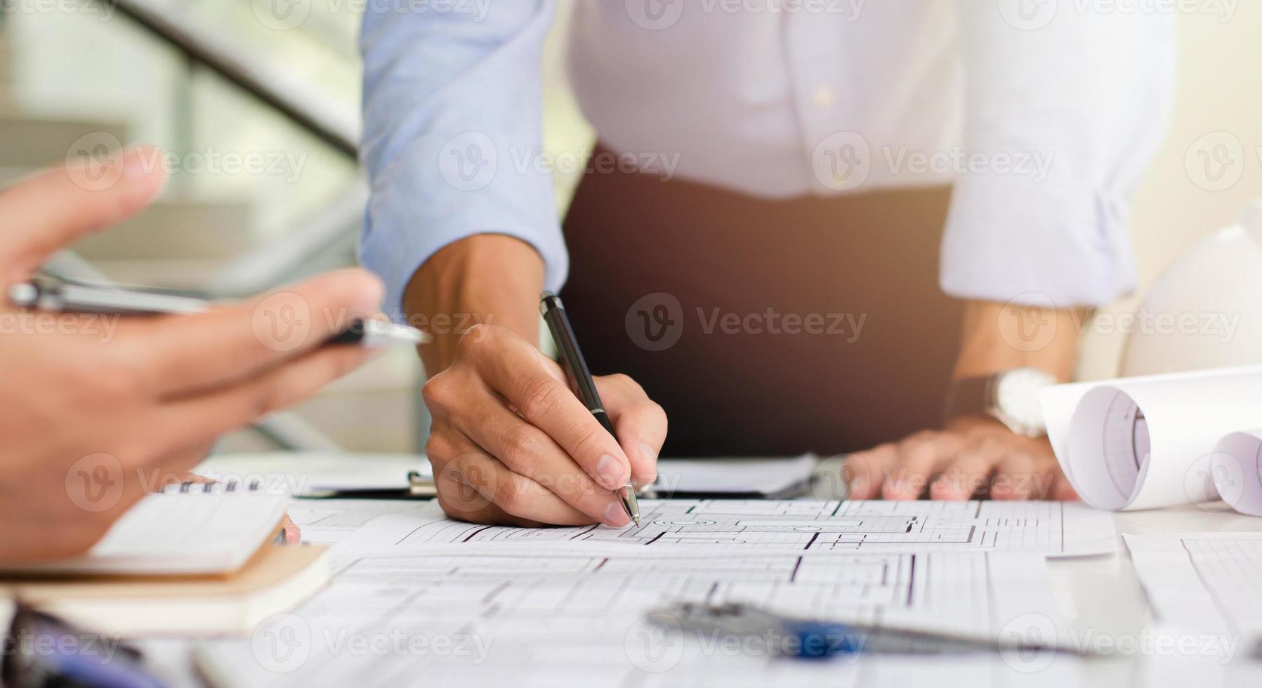 ingénieur qui planifie une ébauche de la structure. avec du matériel d'architecte et des discussions d'équipe sur les plans architecturaux aux bureaux des bureaux modernes. photo