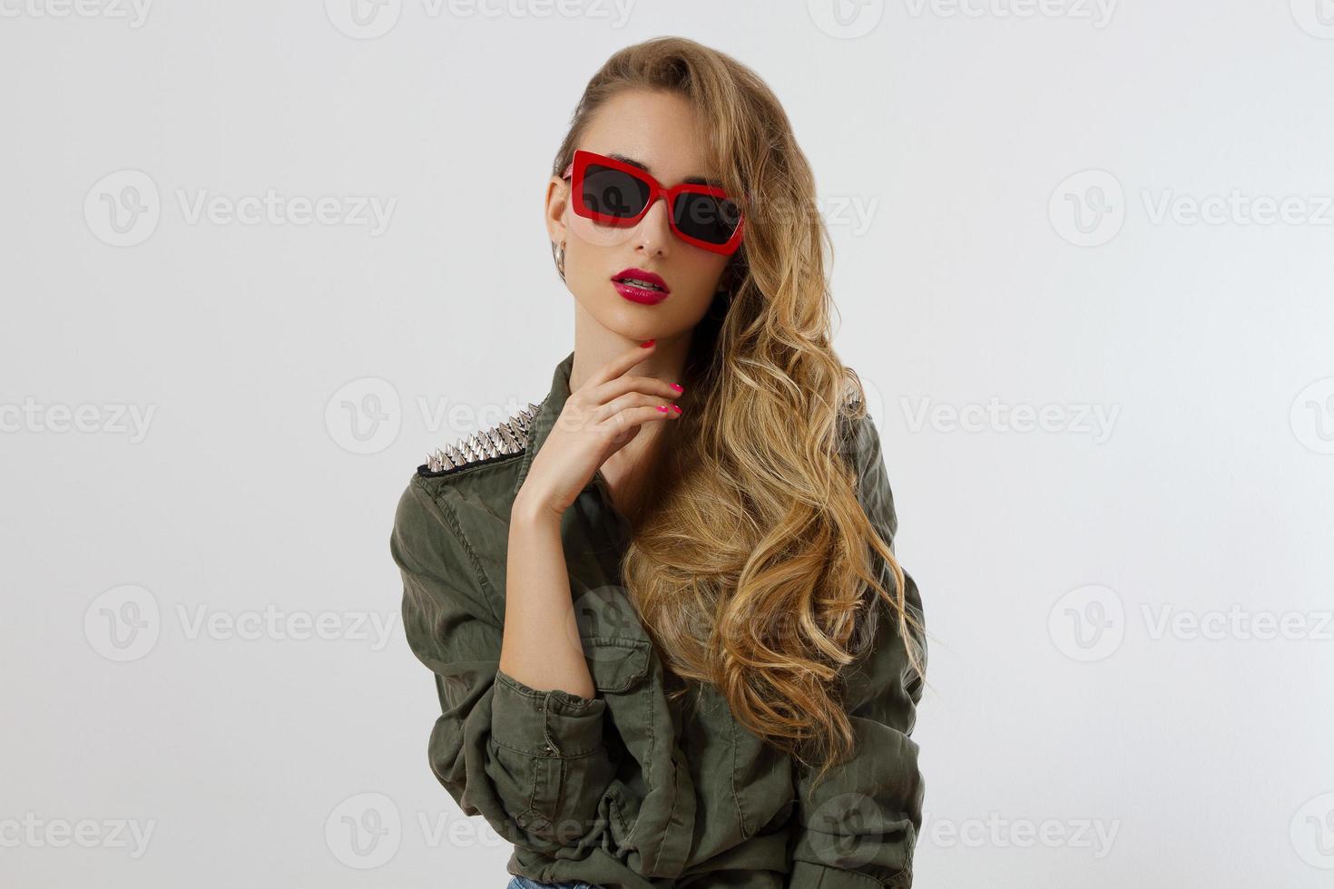 visage de femme gros plan dans des lunettes de soleil rouges isolés sur fond blanc. fille en chemise, maquillage des lèvres rouges. concept de beauté de mode. belle peau de visage et accessoires à la mode. cheveux longs style glamour photo