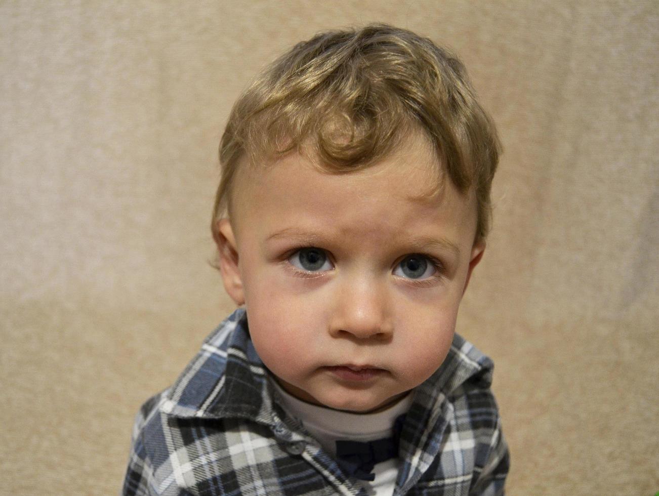 Beau petit garçon avec un photographe de pose de visage d'enfant photo