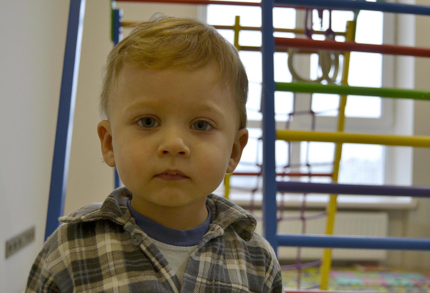 Beau petit garçon avec un photographe de pose de visage d'enfant photo