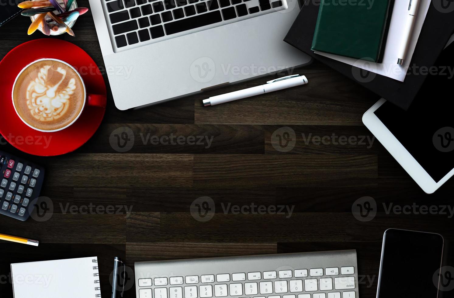 trucs de bureau avec tablette, ordinateur portable, smartphone et bloc-notes de tasse à café et documents vue de dessus. photo