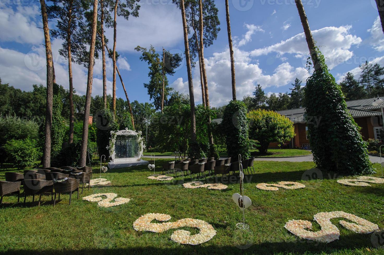 arche de mariage carrée en métal décorée de fleurs d'anthurium, d'orchidées et de roses de couleur rose et corail. style moderne et insolite, mariage en plein air sur la cascade de tibumana bali. photo