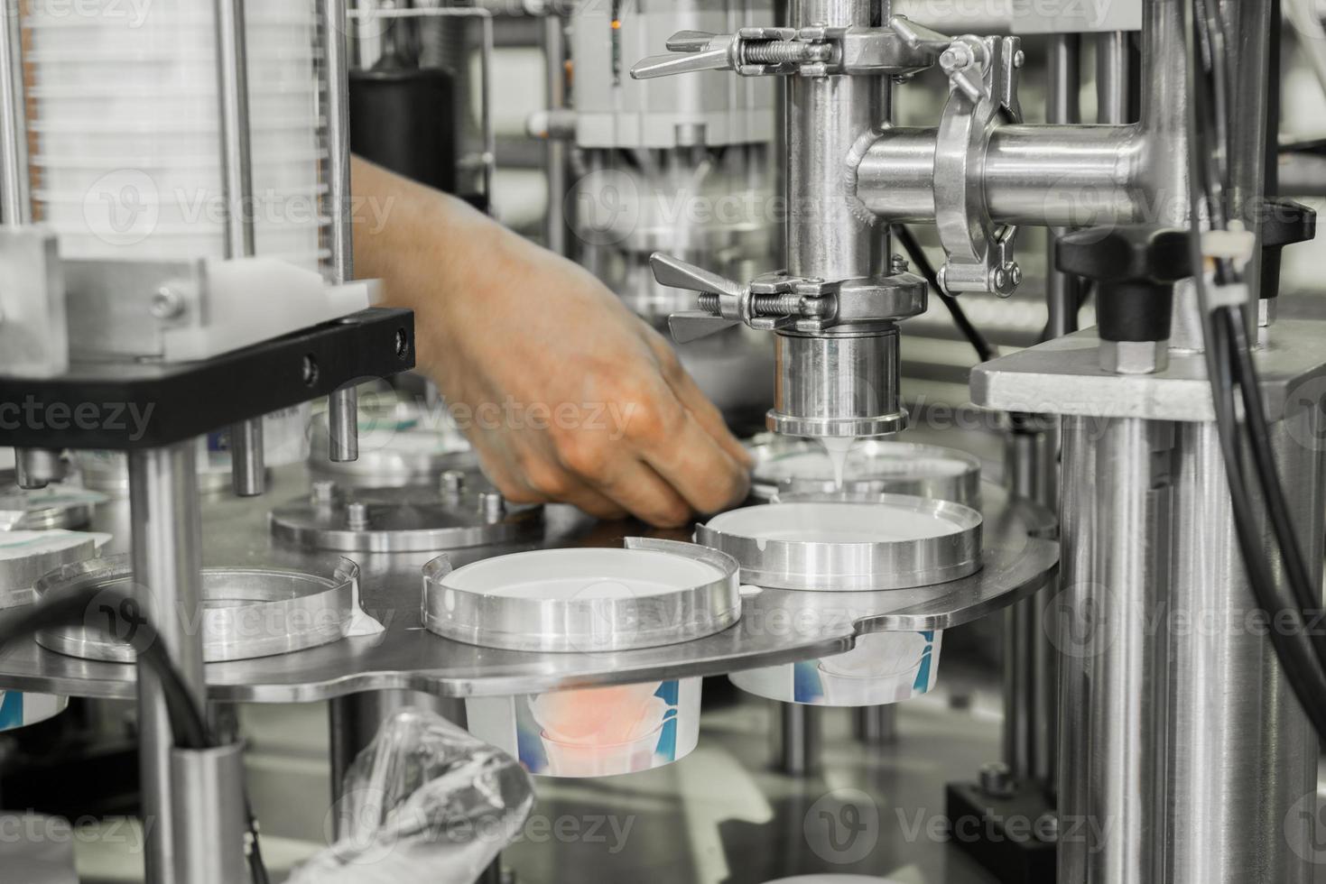 production et embouteillage de yaourt dans des gobelets en plastique. équipement à l'usine laitière photo