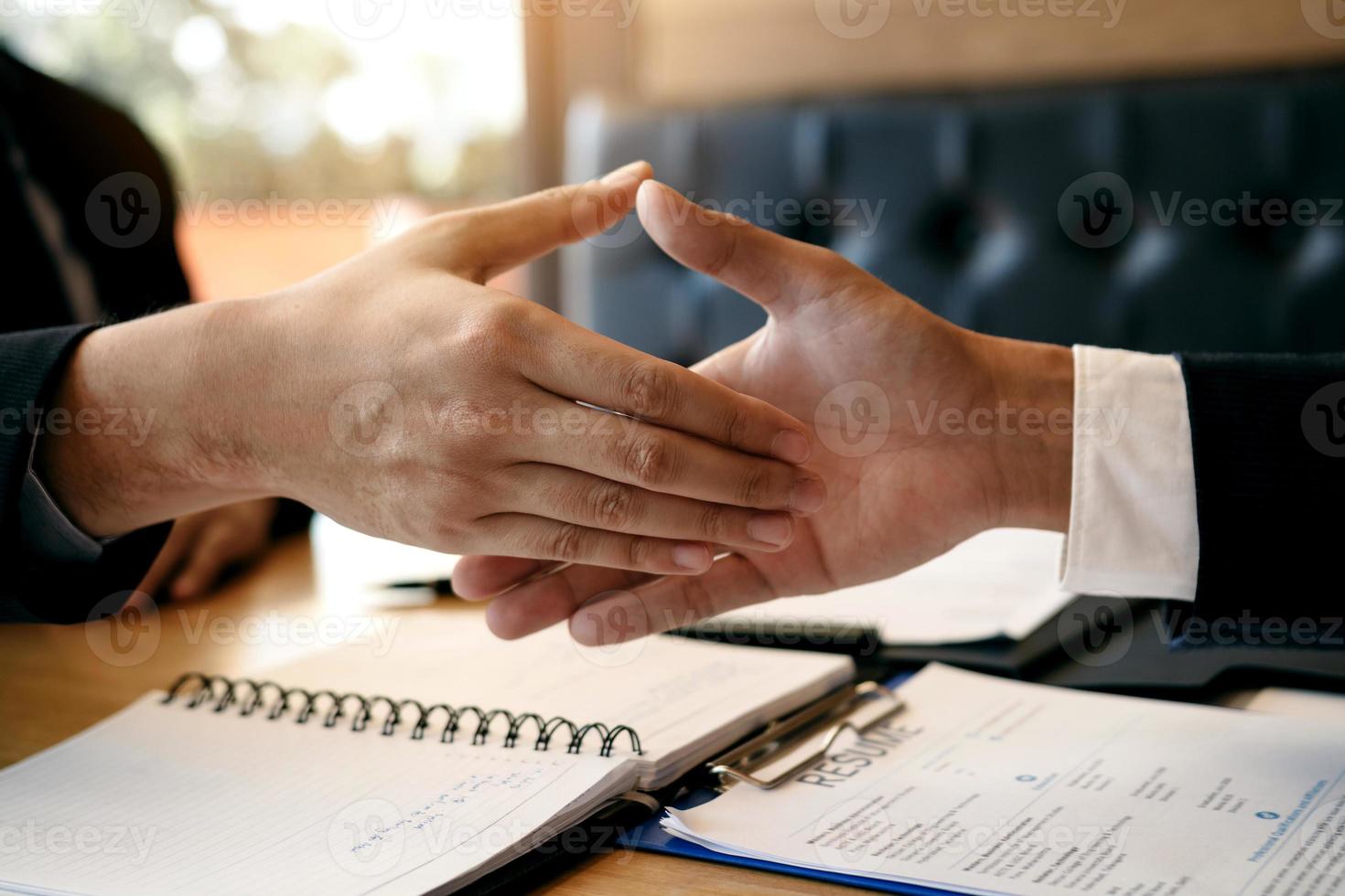 le directeur des chefs de département se serre la main et accepte un nouvel employé dans la salle de bureau. photo